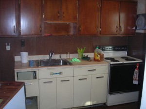 Old site built wood cabinets, metal base cabs, no dishwasher in a very outdated disfunctional galley kitchen
